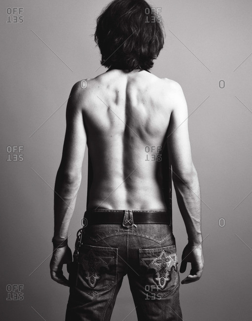 Back view of half naked man wearing jeans