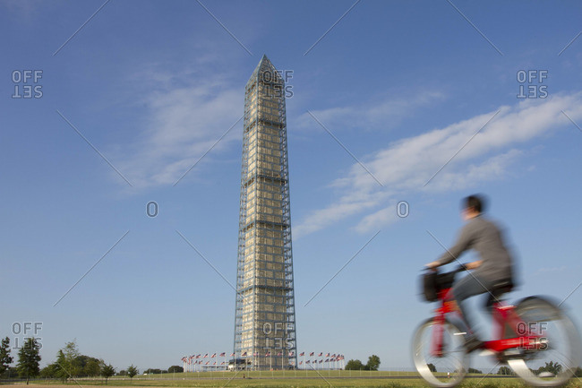 An urban cyclist rides by the Washington Monument.