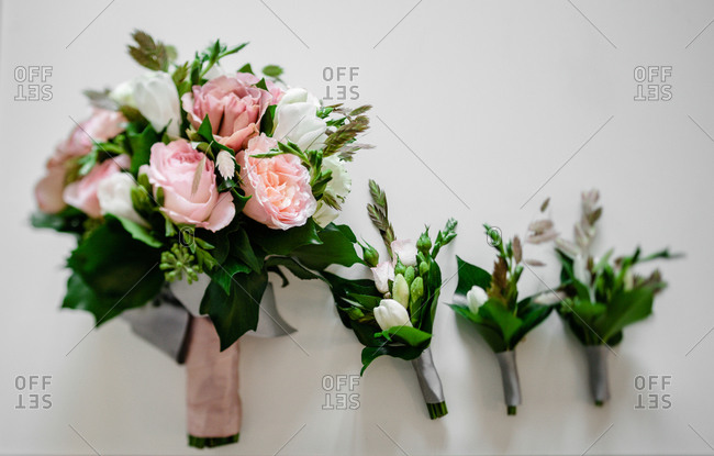 Close up of three boutonnieres and a bridal bouquet