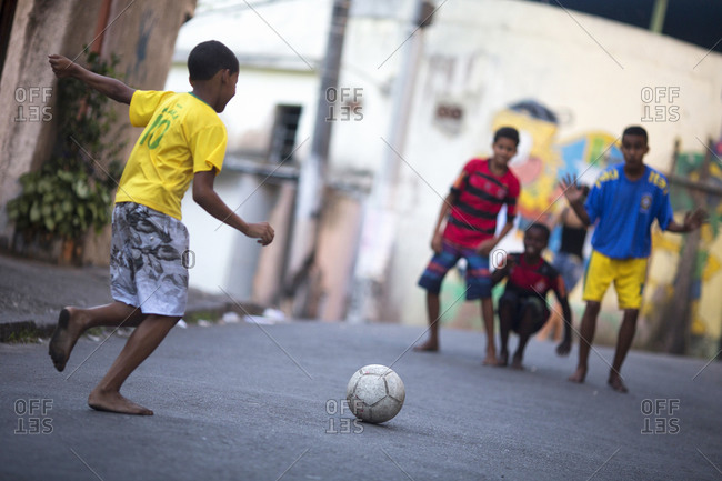 Brazilian children playing football in the streets of Complexo do Alemao favela
