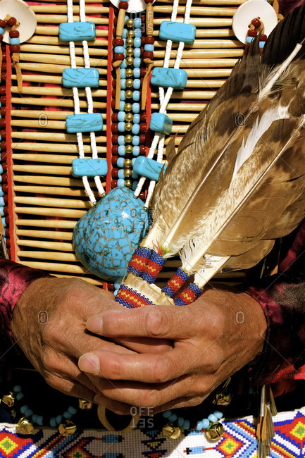 Man wearing a native bone breast plate and eagle feathers in Okhay Owingeh Pueblo, New Mexico, USA