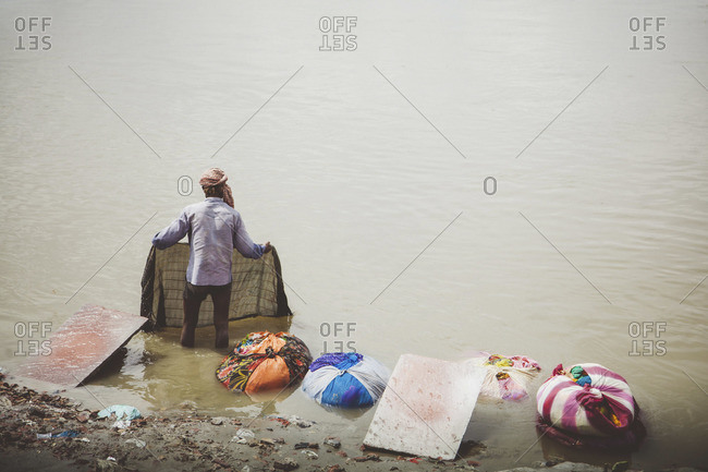 Man washing clothes in a river in Agra, India