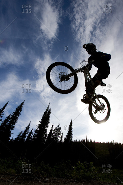A mountain biker doing a stunt on the Runaway Train trail in Whitefish, Montana