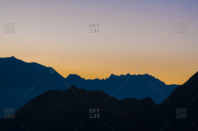 Silhouette of mountains at sunrise with colorful sky, Ossola, Italy
