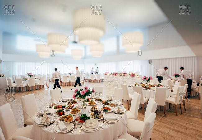 Waiters setting tables for wedding reception