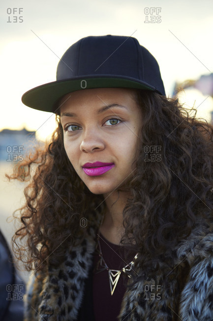 Young woman wearing pink lipstick and a baseball hat