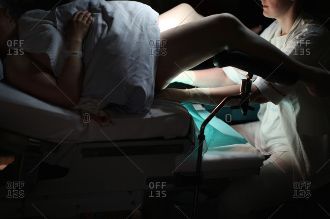 Woman being sewn after childbirth