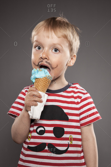 Portrait of little boy with painted beard and ice cream