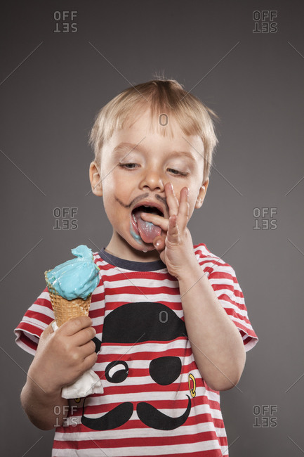 Portrait of little boy with painted beard and ice cream