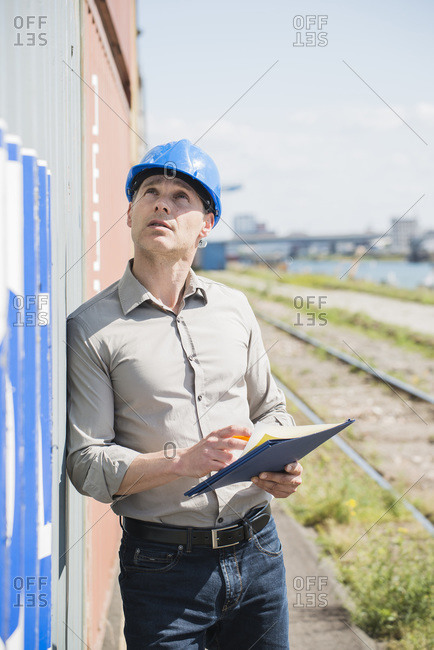 Portrait of man with blue safety helmet checking cargo containers