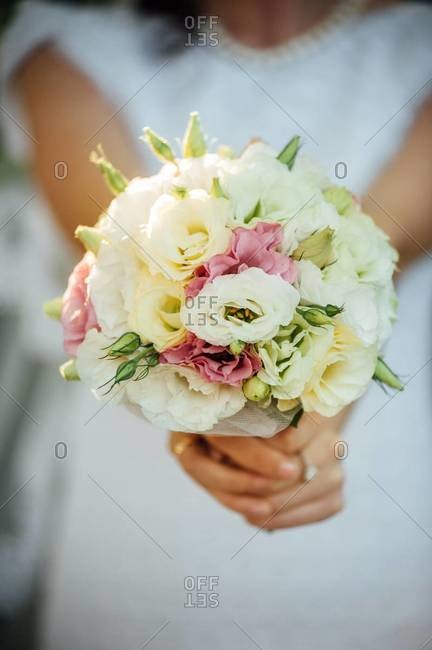 Mid section view of a bride holding bridal bouquet