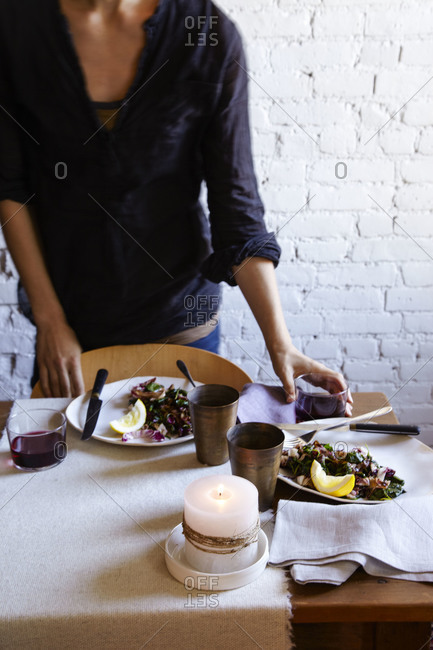 Woman standing by a table set for dinner