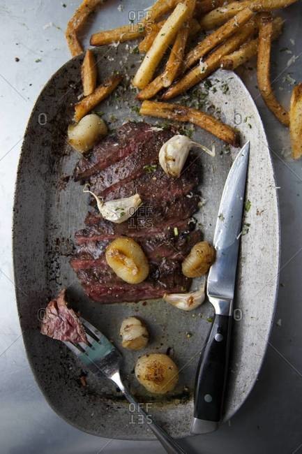 Top view of steak with french fries on tin plate