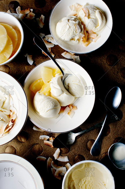 Ice cream scoops with pineapple and toasted coconut flakes
