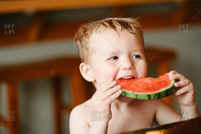Boy biting into a slice of watermelon