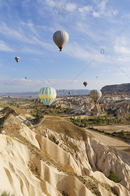 Hot air balloons hovering over tuff rock formations at Goereme National Park, Turkey