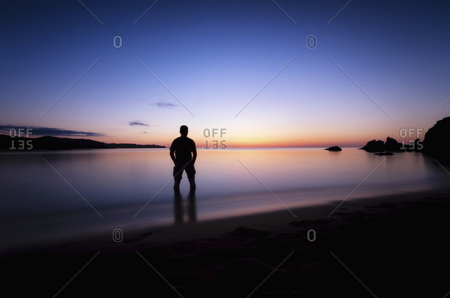 Man watching sunset at Playa de Cavalleria, Menorca