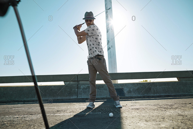 Man playing urban golf on street