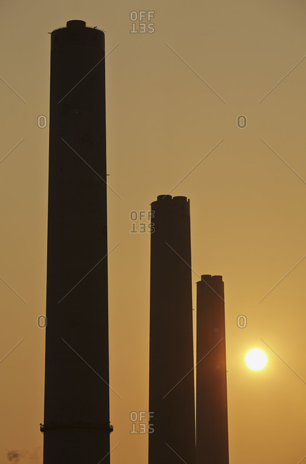 A silhouette of the chimneys of a coal-fired power station at sunset, Lamma Island, Hong Kong