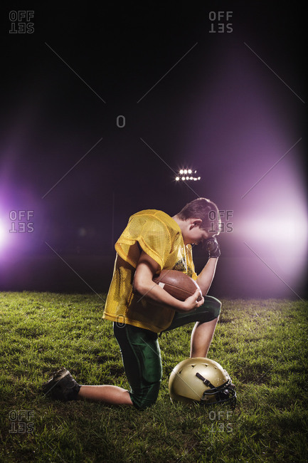 Boy praying before football game
