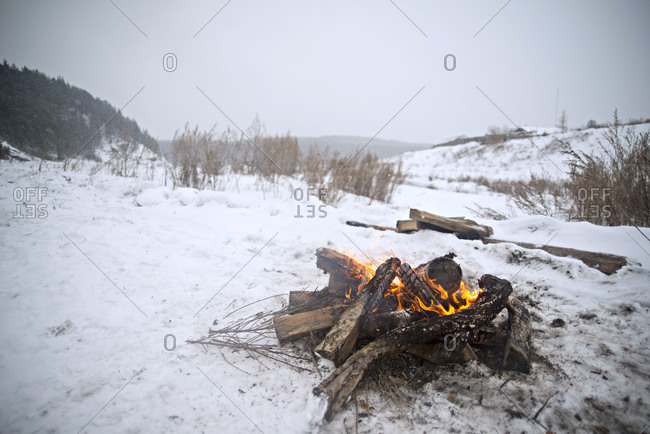 Fading camp fire in winter landscape