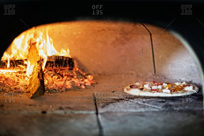Pizza baking in a wood-fired oven