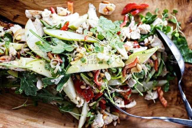 Warm chicken salad with peppers, pears and toasted pine nuts