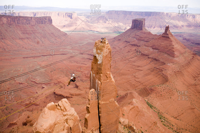 Adventure racer on a Tyrolean Traverse high above the desert in a race in Moab Utah.