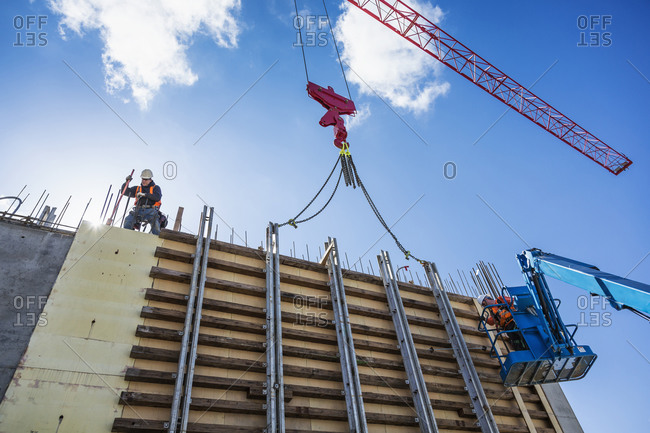 Workers on concrete wall form on construction site