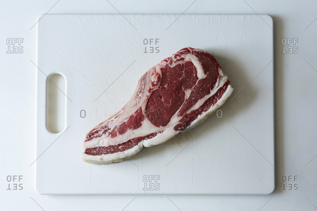 Raw rib eye steak on a cutting board