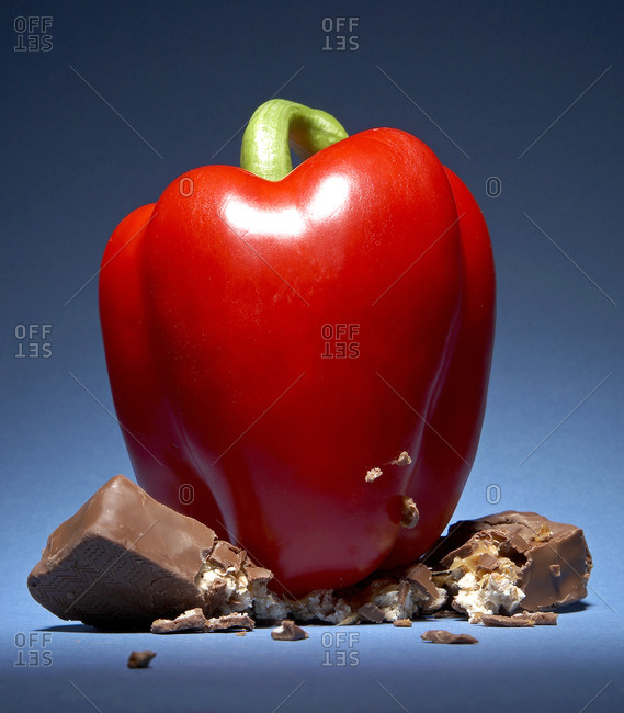 Red bell pepper smashing a chocolate bar