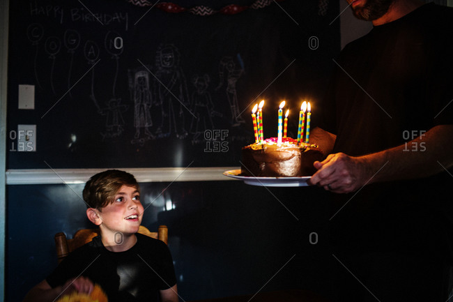 Man serving a birthday cake for a boy