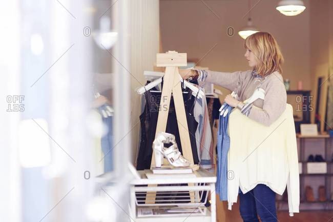 Assistant arranging clothes in a boutique