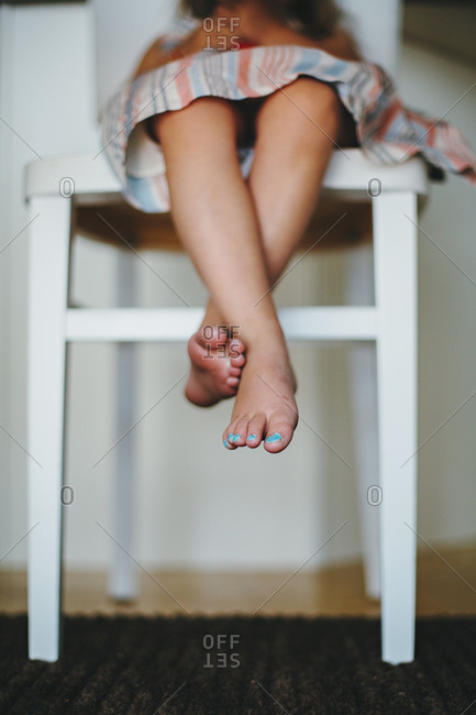 Girl dangling her feet from a chair
