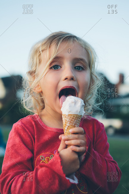 Cute three year old girl enjoying ice cream cone