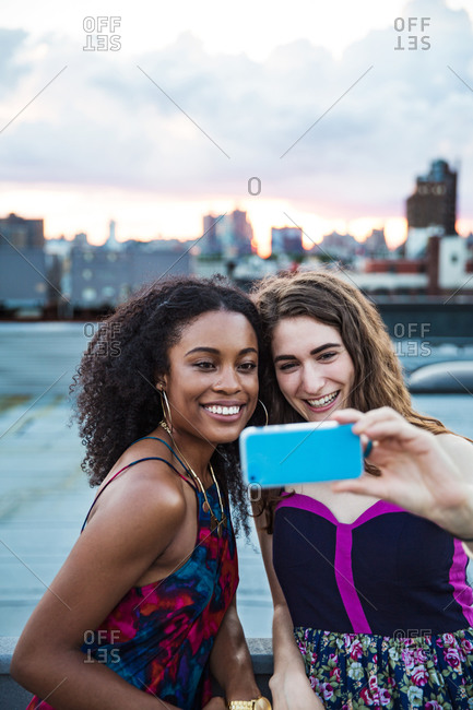 Friends taking a self-portrait at a rooftop party, Brooklyn