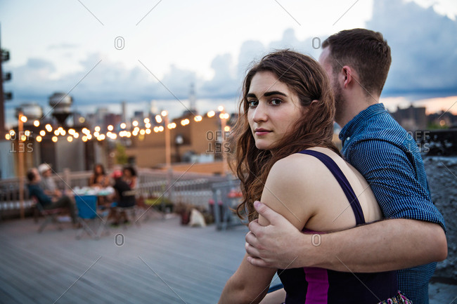 Couple at the edge of a rooftop party, Brooklyn