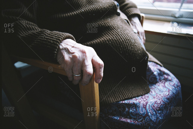 Mid-section of an elderly lady sitting in a hospital complex