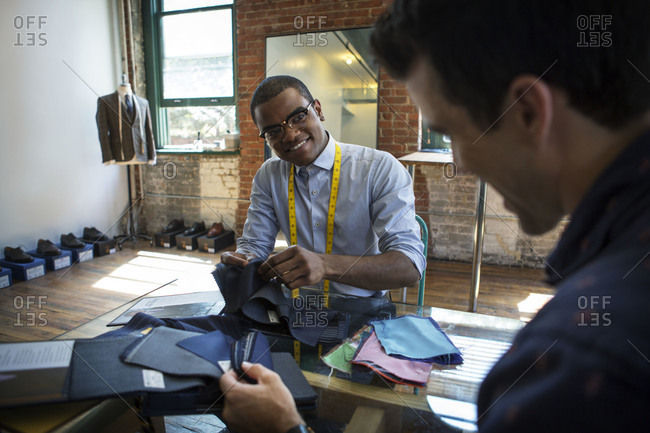 Tailor choosing fabrics with a customer