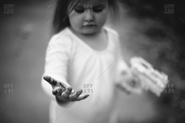 Little girl showing dirt on his hand