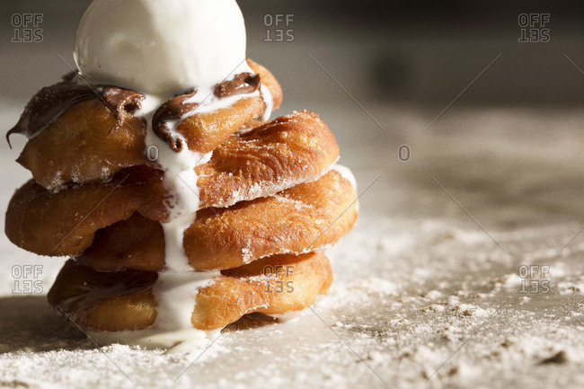Stack of deep-fried dough with hazelnut cream and a scoop of melting ice cream