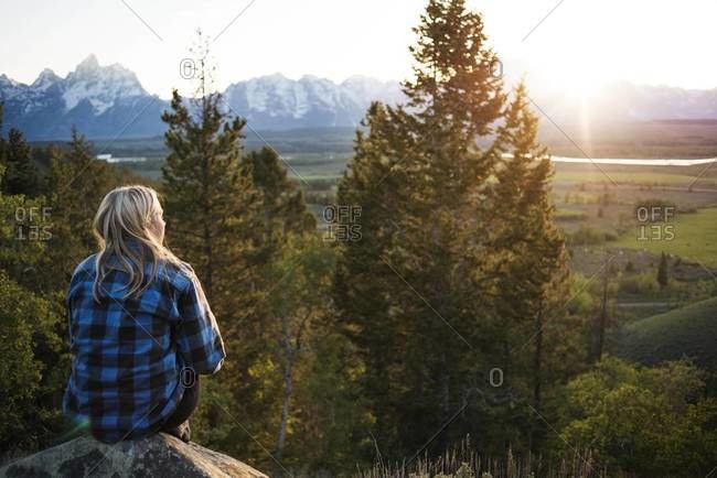 Woman watching the sunset from a rock