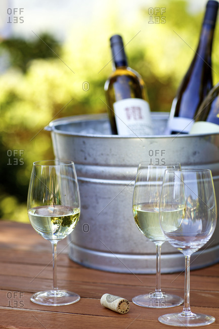 White wine in glasses with bottles in an ice bucket