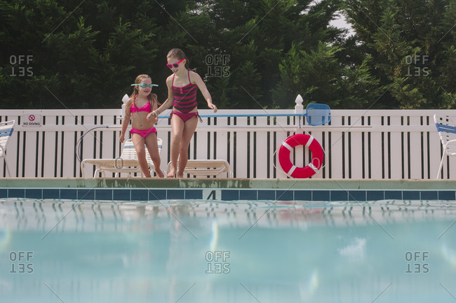 Young girls preparing for a jump at a swimming pool