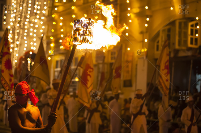 A man holding a torch filled with burning coals at the Esala Perahera parade, in Kandy, Sri Lanka