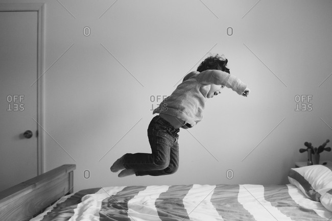 Boy jumping around on a bed
