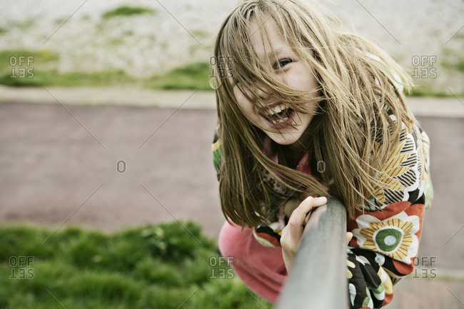 Happy young girl sliding down a railing on a stairway