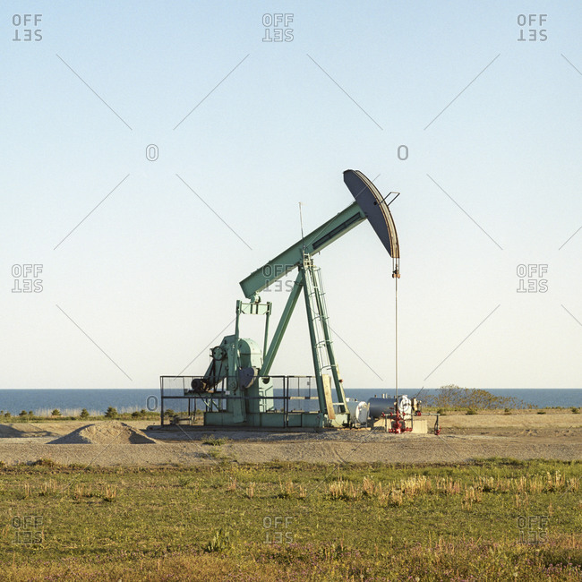 A pump jack pumping oil next to Lake Erie