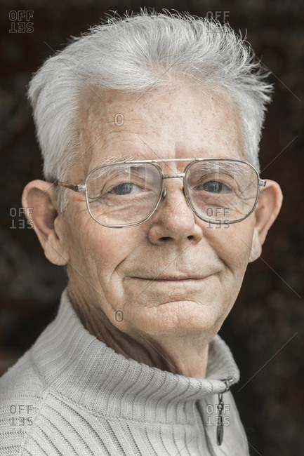 Close-up portrait of confident senior man wearing glasses