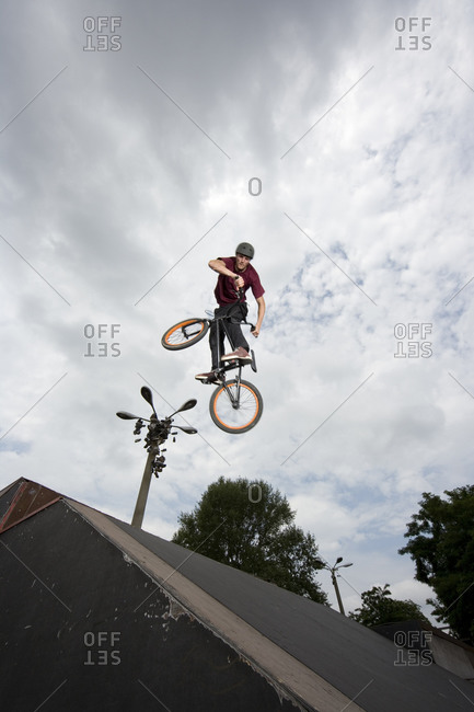 A young man in mid-air doing a stunt on a BMX bike